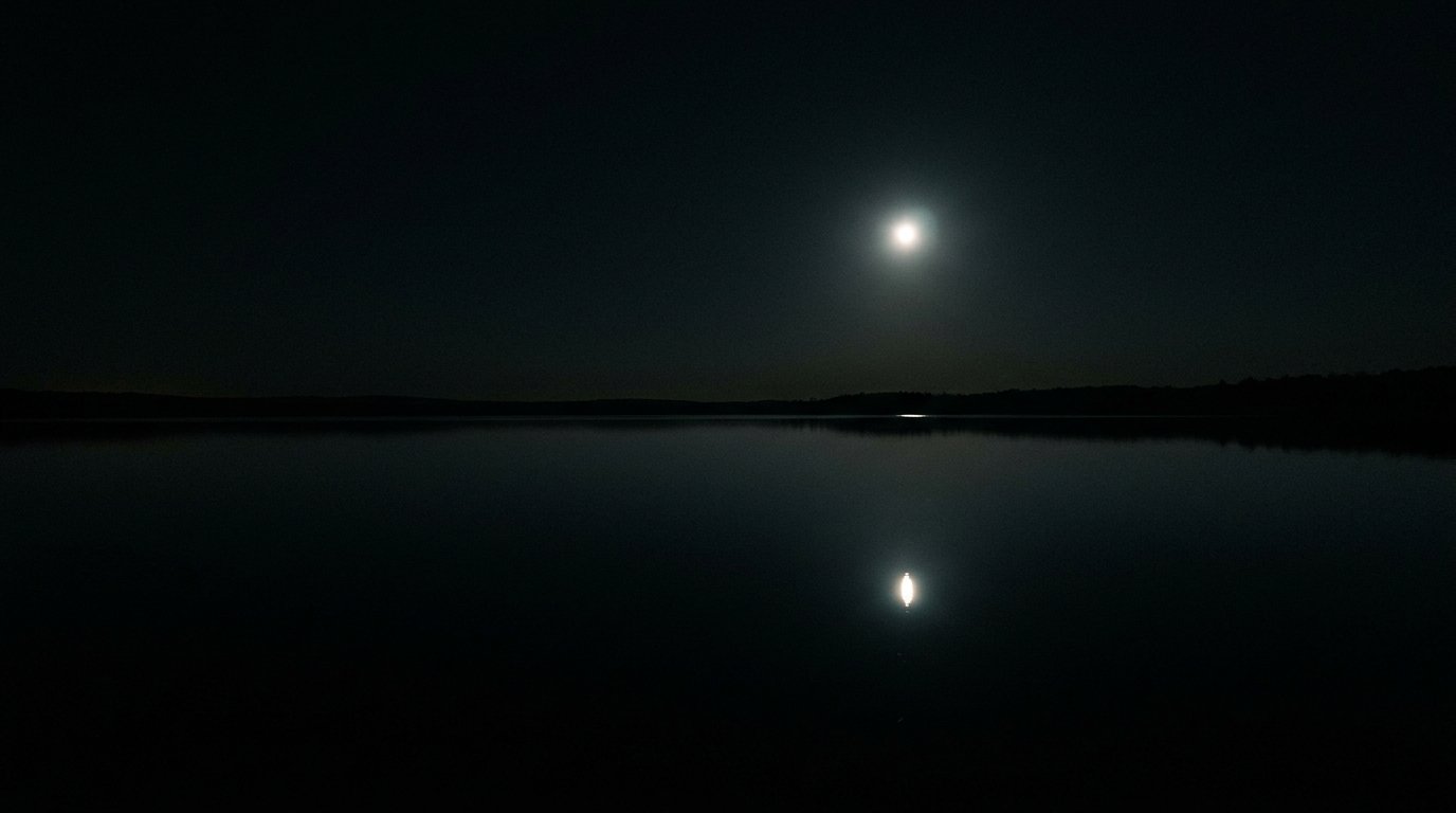 La luna reflejada en un lago en calma durante la noche: Ananda, la dicha serena que ya es tu fondo.